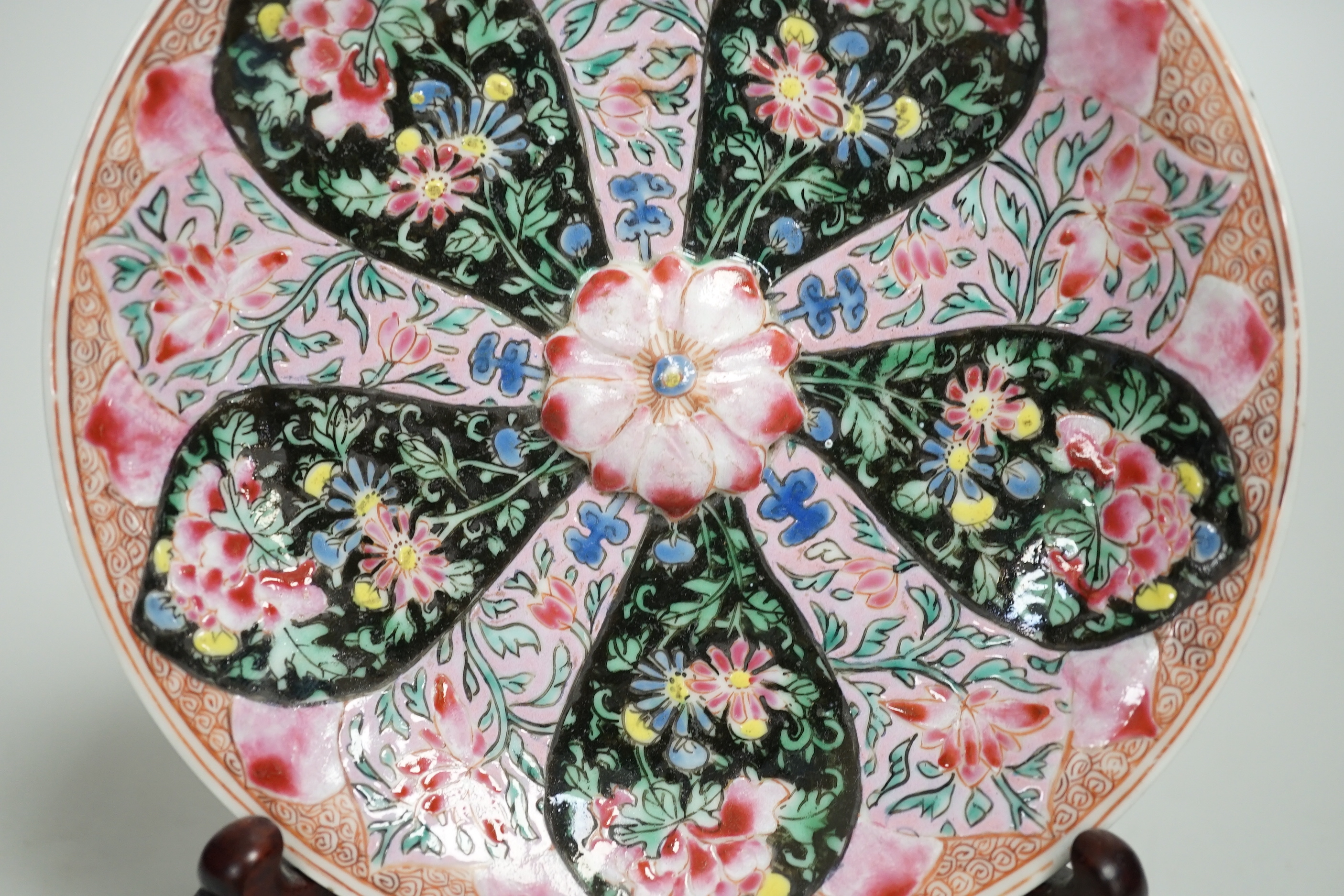 A Chinese famille rose cup stand, early Qianlong period, decorated in relief with a flowerhead, 15cm in diameter